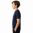 A boy in profile wearing a navy blue short-sleeve athletic t-shirt with a small white chest logo, set against a plain white background.
